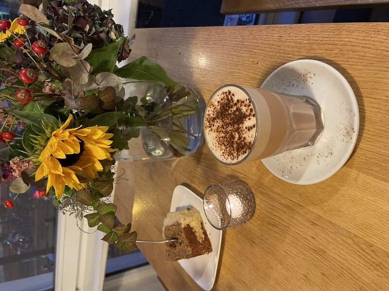 Sonnenblumen, Kaffee und Kuchen auf einem Holztisch