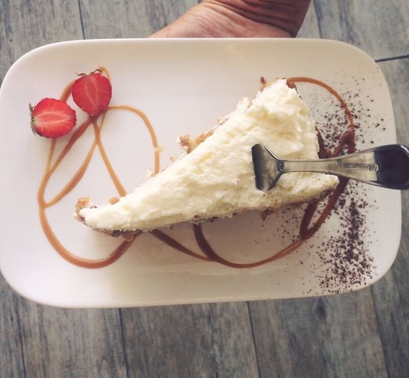 Ein Stück Carrot Cake mit Sahnehaube und Fruchtspiegel