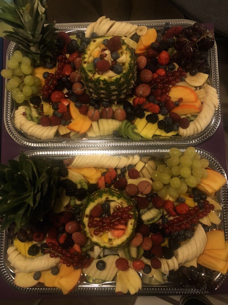 Zwei große Cateringplatten mit Hummus, Gemüse und Obst