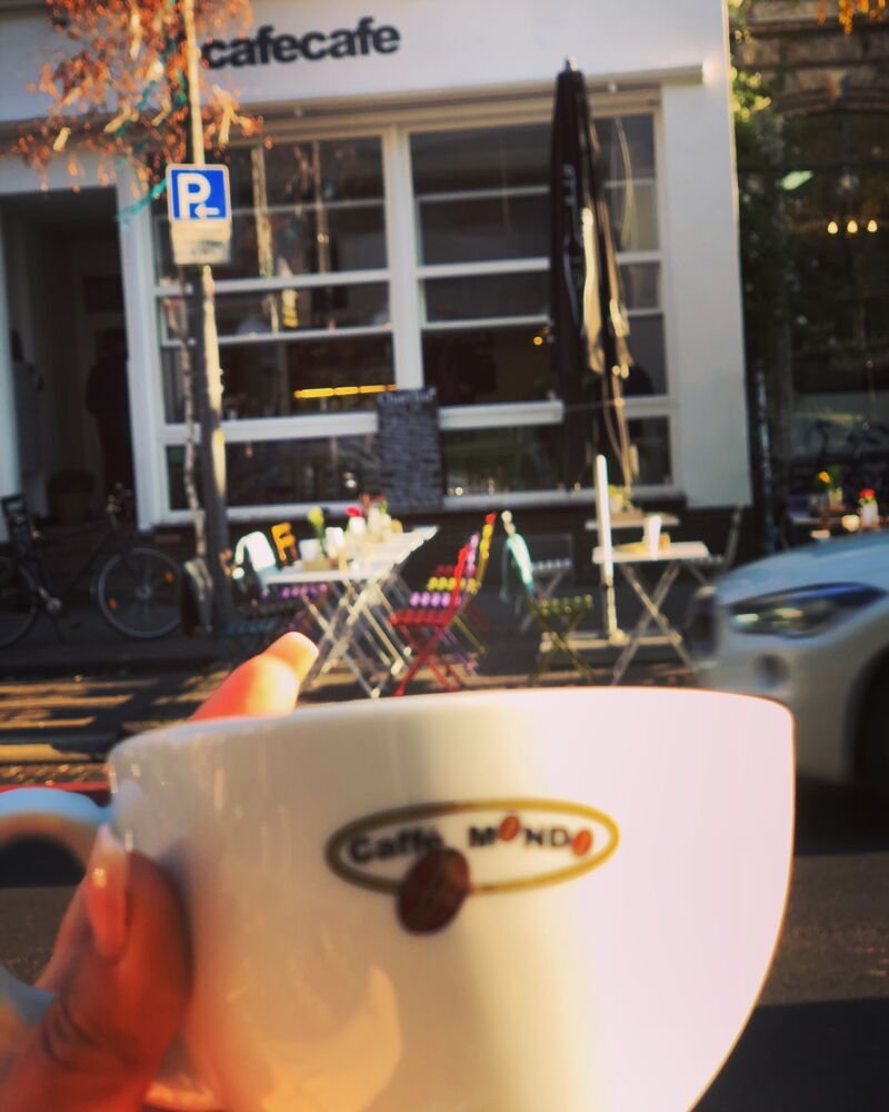 Cappuccino-Tasse vor dem Schaufenster des cafecafe Ehrenfeld