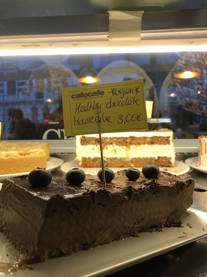 Kuchenstücke in der Vitrine mit handgeschriebenem Schild